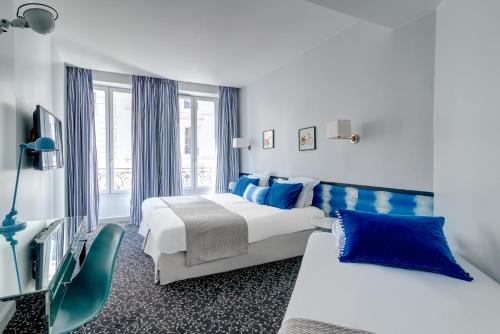 una camera d'albergo con due letti e una sedia di Hotel Acadia - Astotel a Parigi