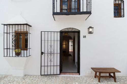 a white building with a door and a wooden table at Con encanto, relajante, céntrica in Fuengirola