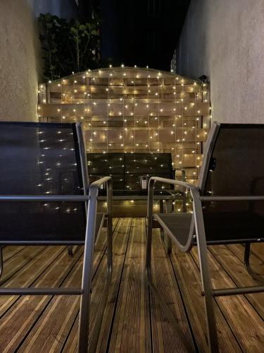 un groupe de chaises assises sur une terrasse éclairée dans l'établissement Terrasse Saint-Pierre - Centre historique Clermont-Ferrand, à Clermont-Ferrand