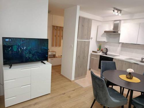 cocina y comedor con mesa y TV en Apartment Longin, en Zadar