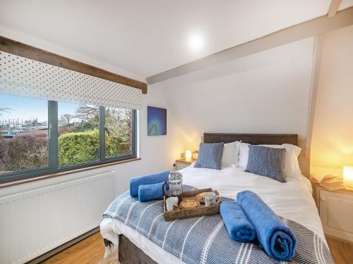 a bedroom with a bed with blue towels on it at The Loft in Yealmpton