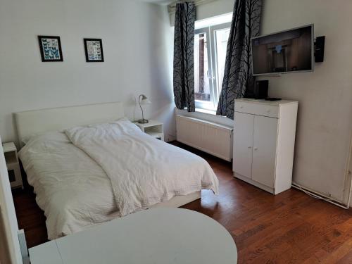 a white bedroom with a bed and a window at Guest House Ilica2rooms in Zagreb
