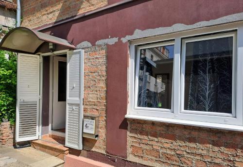 a window with white shutters on a brick building at Guest House Ilica2rooms in Zagreb
