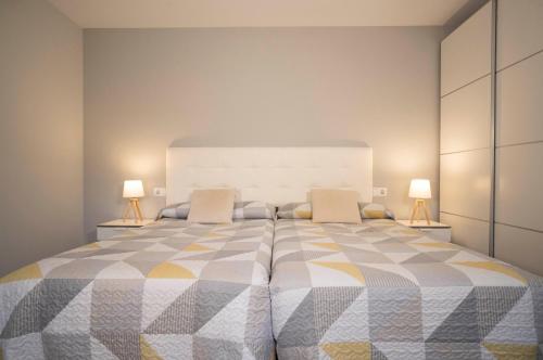 a bedroom with a large bed with two lamps at Apartamentos Terraza Ega in Estella