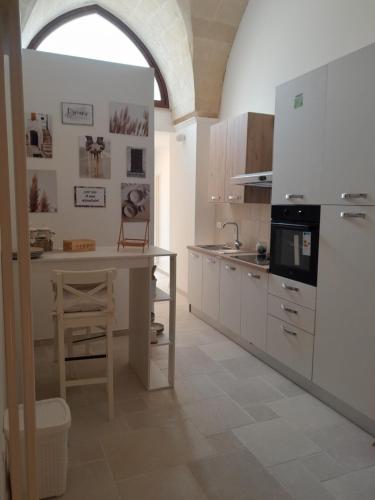 una cucina con armadi bianchi e un tavolo di Core a Core Suite a Lizzano