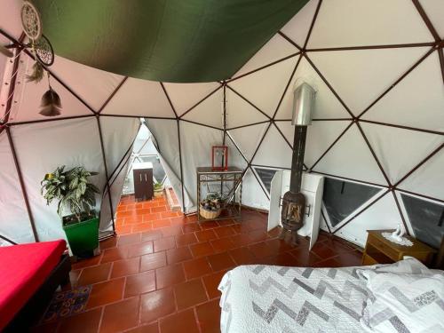 una habitación con una tienda de campaña con una cama en ella en Glamping Bosque del Colibri, en Guatavita
