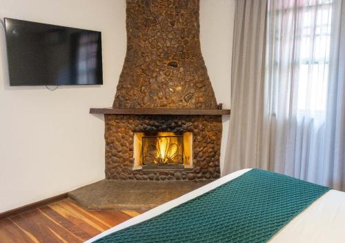 a stone fireplace in a room with a bed at Kastel Pedra Bonita in Petrópolis