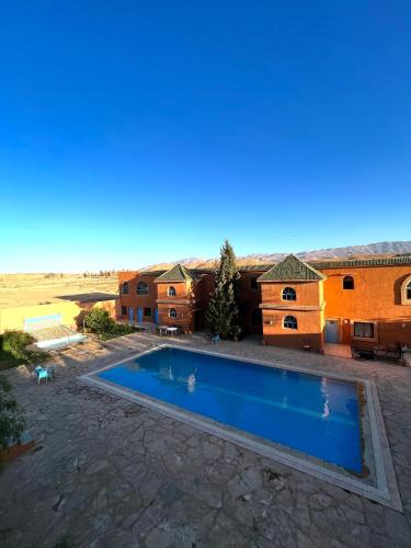 a swimming pool in a yard with a house at Hotel Kasbah Asmaa in Midelt