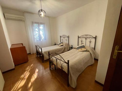 a bedroom with two beds and a window at Villa Mariaurelia in Sanalvò
