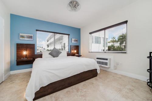 um quarto com uma cama grande e 2 janelas em Starlite Hotel em Miami Beach