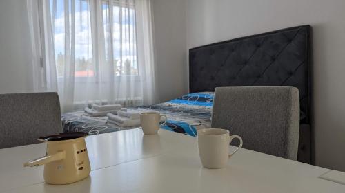 a room with a table with two chairs and a bed at Iva Lux Apartments in Žabljak
