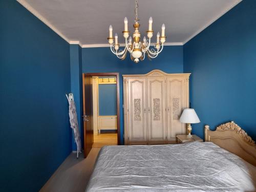 - une chambre bleue avec un lit et un lustre dans l'établissement Cabacum Beach Residence апартамент Голубая лагуна, à Varna