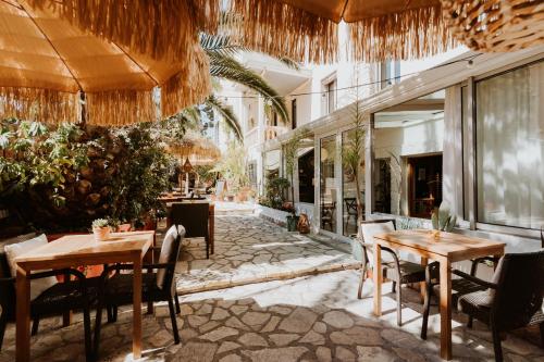 un restaurante con mesas y sillas en un patio en Hôtel Le Petit Castel, en Antibes