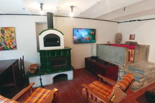 a living room with a fireplace and a green stove at Casa San Quirico Agnone in Agnone