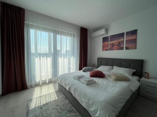 a bedroom with a large bed and a large window at Central Park Studio in Onești