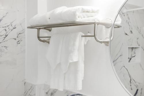 a bathroom mirror with white towels on a towel rack at Starlite Hotel in Miami Beach