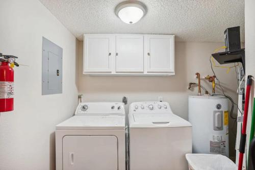 a kitchen with white cabinets and a washer and dryer at Beach Palms- Unit 102 in Clearwater Beach