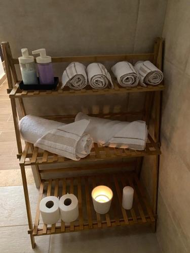 estante con toallas y artículos de aseo en el baño en MiaDabia Supreme, en Madaba