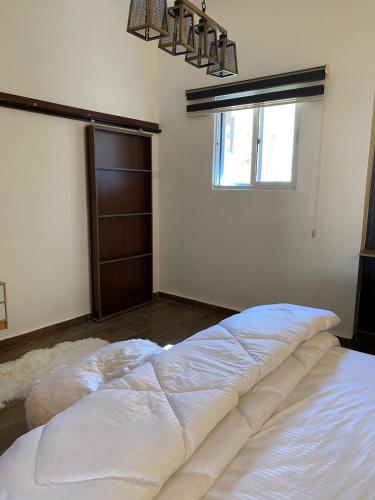 1 cama blanca grande en una habitación con ventana en MiaDabia Supreme, en Madaba