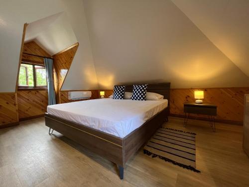 a bedroom with a large bed with two pillows on it at Digwa Beach Chalet in La Digue