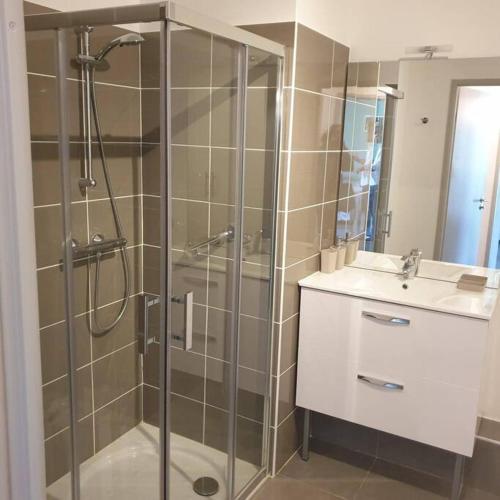 une salle de bain avec une douche en verre et un lavabo dans l'établissement T2 neuf près des plages et commerces, à Sète