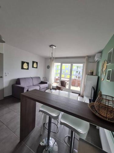 Il dispose d'une cuisine et d'un salon avec un bar et des tabourets. dans l'établissement T2 neuf près des plages et commerces, à Sète