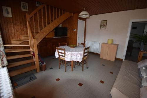 a dining room with a table and a staircase at Gîte HAUTEROCHE BOISSON in Crançot