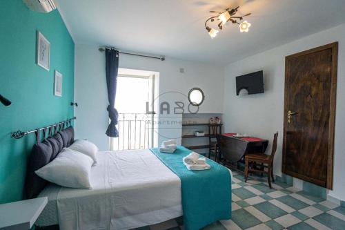 ein Schlafzimmer mit einem Bett und einem Tisch in einem Zimmer in der Unterkunft Choros in Tropea