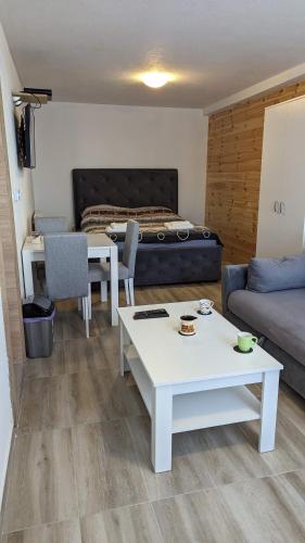 a living room with a couch and a table and a bed at Iva Lux Apartments in Žabljak