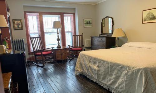 Lakeside Inn في Lakeside: غرفة نوم بسرير ومكتب وكراسي
