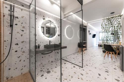 a bathroom with a glass shower with a rock wall at Furla Suites Athens in Athens