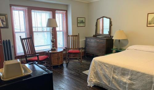 - une chambre avec un lit, une commode et un miroir dans l'établissement Lakeside Inn, à Lakeside