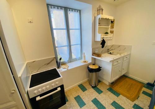 a small kitchen with a sink and a window at Le Duplex de Bellevue - Futuroscope - La Conciergerie. in Jaunay-Marigny