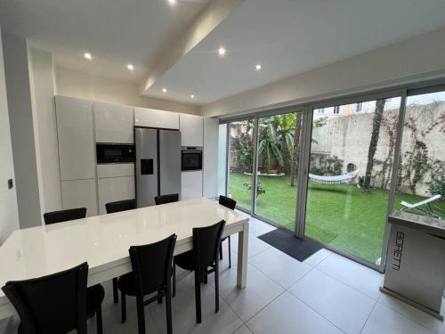 une cuisine avec une table et des chaises ainsi qu'une grande fenêtre dans l'établissement Amazing Stay - Azurenting, à Cannes