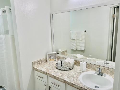 a bathroom with a sink and a large mirror at Deluxe Stays in Kissimmee