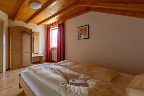 ein Schlafzimmer mit einem Bett in einem Zimmer mit einem Fenster in der Unterkunft Santlhof-Weissburgunder in Kurtatsch