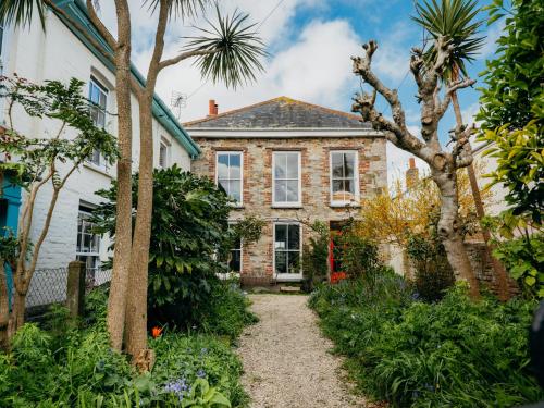 an old brick house with a garden in front of it at Enchanted Rose Garden House in Falmouth