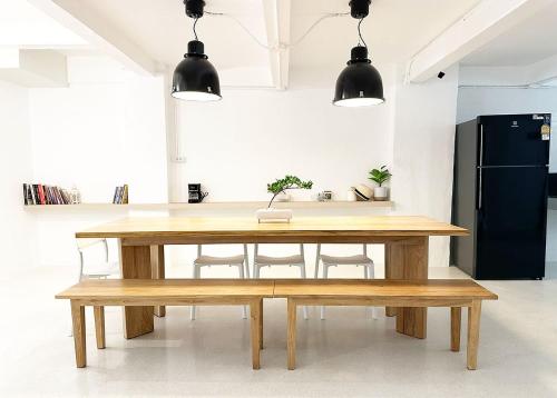 a kitchen with a wooden table and a bench at River Home Bangkok in Bangkok