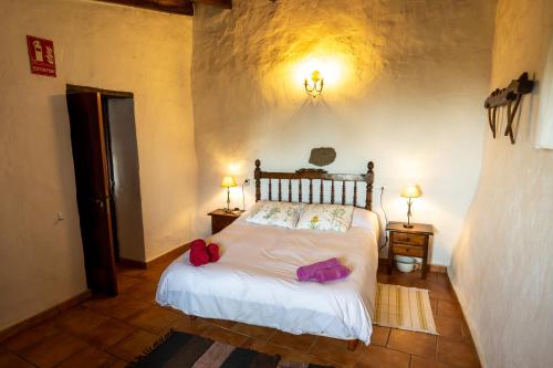 Un dormitorio con una cama con dos bolsas. en Casa rural La Jarita, en El Pinar de El Hierro