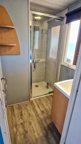 une salle de bain avec une douche, un lavabo et un miroir dans l'établissement Mobil home 6 personnes camping 4* Les Pins Maritimes, à Hyères