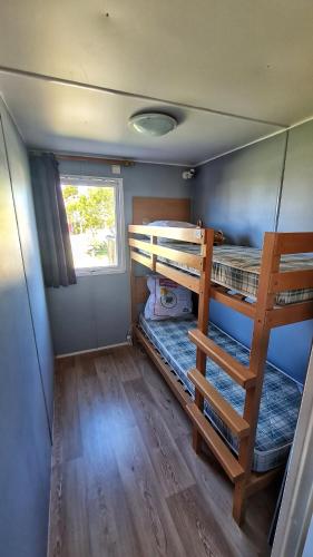 a small room with two bunk beds and a window at Mobil home 6 personnes camping 4* Les Pins Maritimes in Hyères