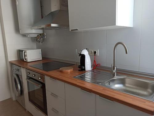 eine Küche mit einer Spüle und einer Arbeitsplatte in der Unterkunft Apartamento Bolboretas con parking privado in Ares