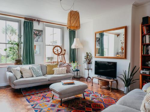 ファルマスにあるEnchanted Rose Garden Houseのソファとテレビのあるリビングルーム