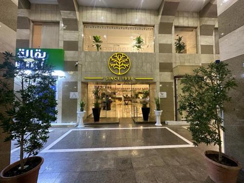 um lobby de uma loja com vasos de árvores em frente em Emaar Elite Al Madina Hotel em Medina