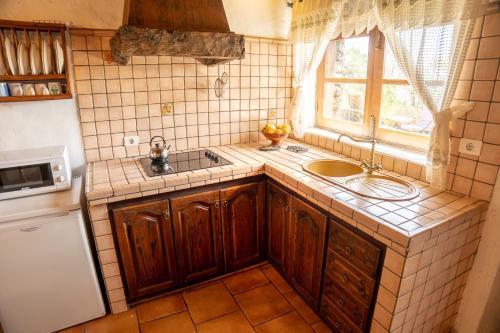 uma pequena cozinha com um lavatório e uma janela em Casa rural La Jarita em El Pinar del Hierro