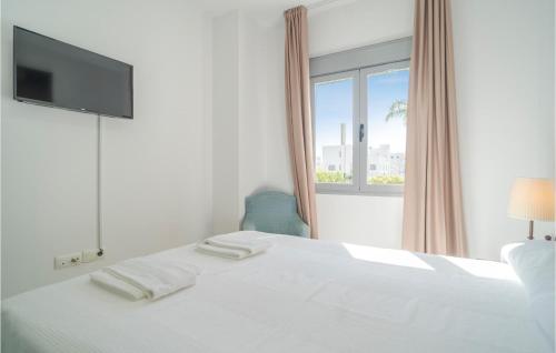um quarto branco com uma cama e uma janela em Gorgeous Apartment In Conil De La Frontera With Kitchen em Conil de la Frontera
