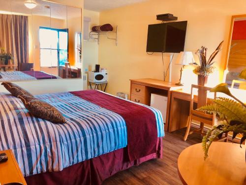 a hotel room with a bed and a desk with a computer at Martin's Inn in Cornwall