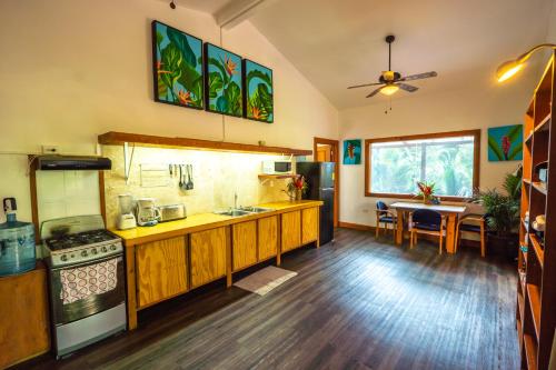 a kitchen with wooden cabinets and a dining room at PirateArts Experience Resort in Bocas del Toro