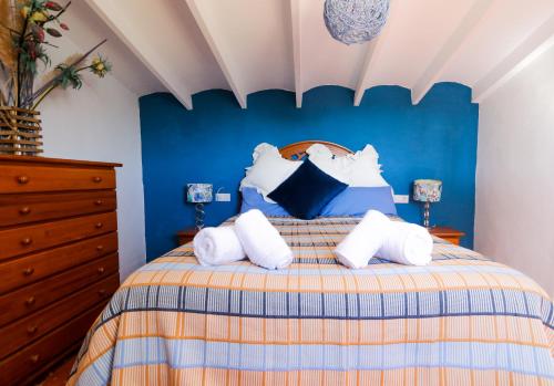 1 dormitorio azul con 1 cama con almohadas blancas en Casa Elizabeth, en Jávea