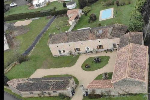 una vista aérea de una casa antigua con patio en Spacious & Characterful 6 Bed Farmhouse with Pool en Vanzay